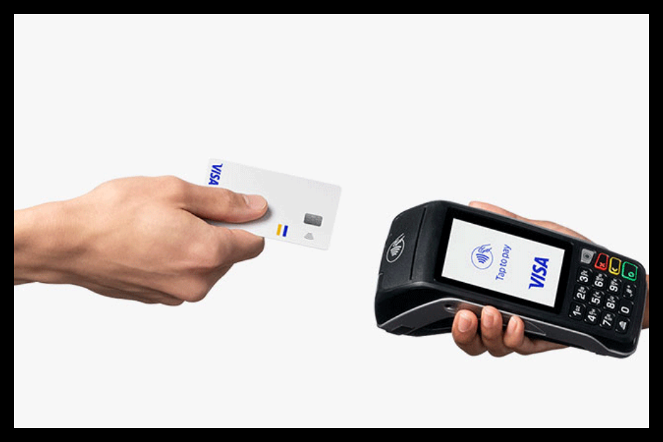 Business owner holding personal credit card next to tax documents and laptop